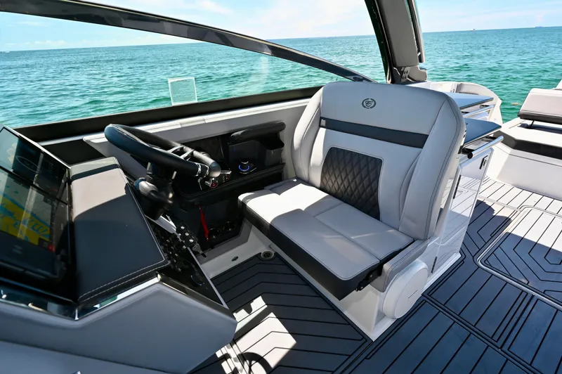  Yacht Photos Pics 2025 Cobalt R33 Outboard boat interior with modern steering and seating, overlooking the ocean.