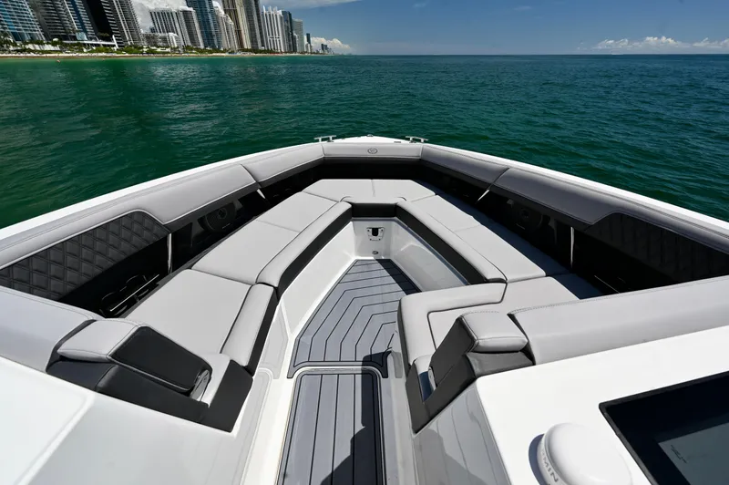  Yacht Photos Pics 2025 Cobalt R33 Outboard boat interior with luxurious seating, ocean view, and city skyline.