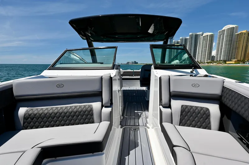  Yacht Photos Pics 2025 Cobalt R33 Outboard boat interior with luxury seating, ocean view, and city skyline.