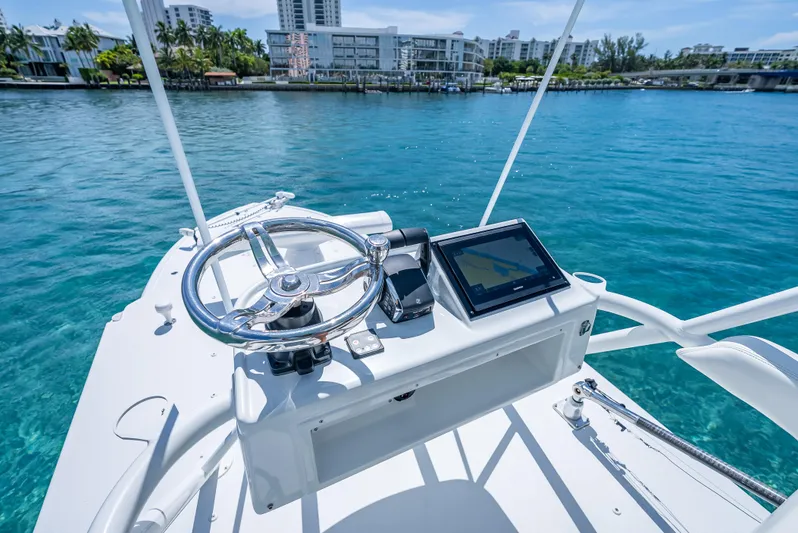  Yacht Photos Pics 2016 Yellowfin 39 Offshore boat helm with steering wheel and navigation display on clear water.