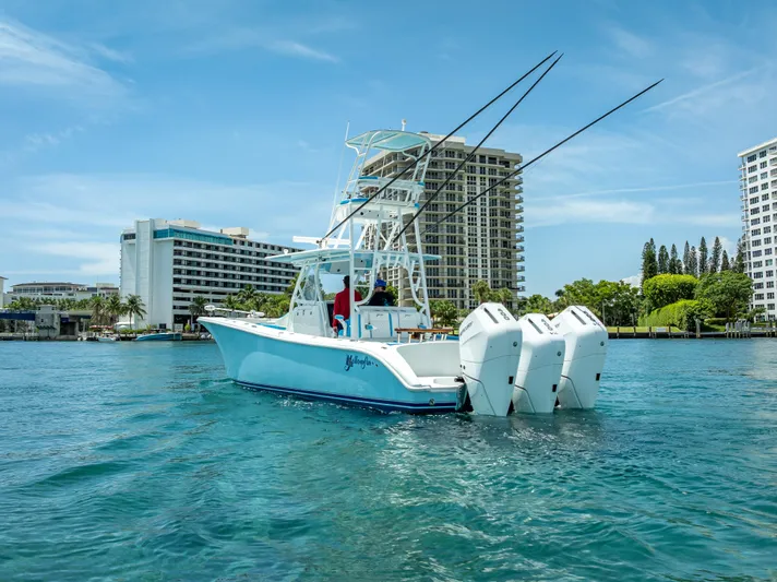  Yacht Photos Pics 2016 Yellowfin 39 Offshore boat with triple engines on clear water near urban buildings.