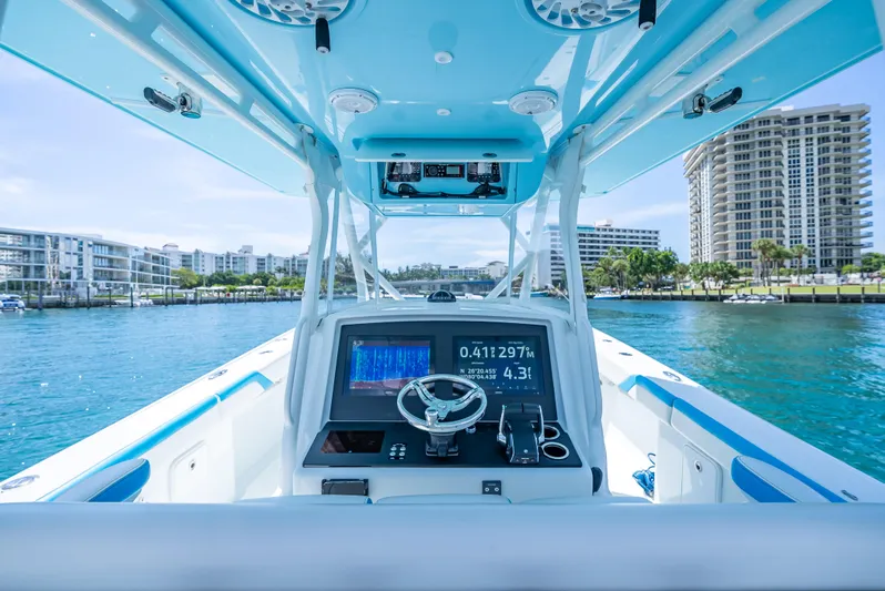  Yacht Photos Pics 2016 Yellowfin 39 Offshore boat dashboard with navigation system, cruising in a coastal cityscape.
