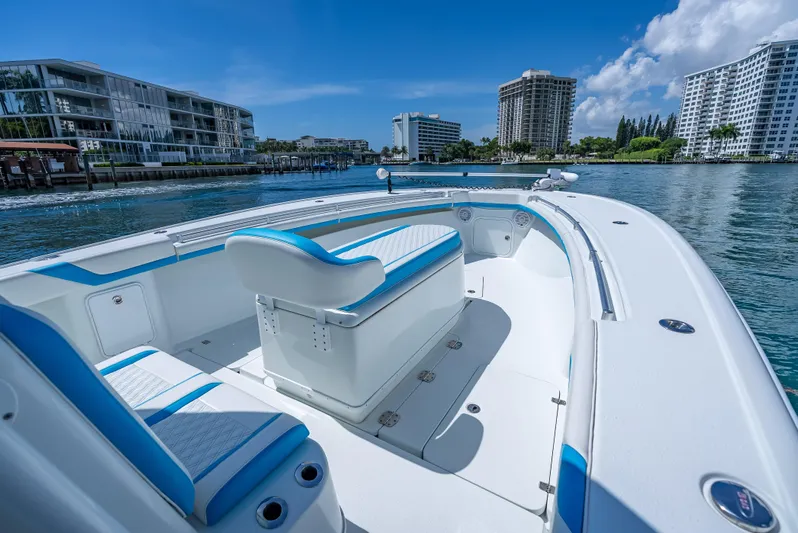  Yacht Photos Pics 2016 Yellowfin 39 Offshore boat on calm water, with modern buildings in the background.