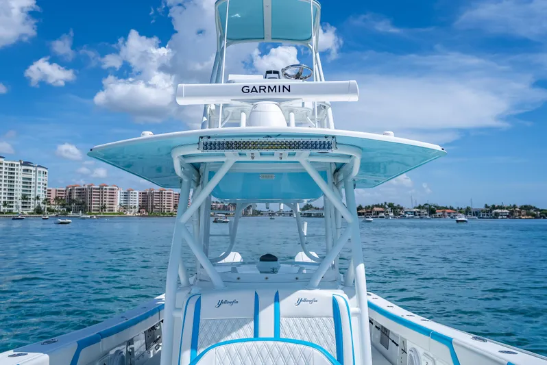  Yacht Photos Pics 2016 Yellowfin 39 Offshore boat on water, clear sky, coastal buildings in background.