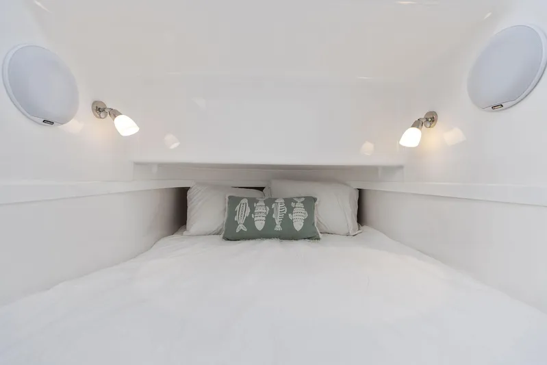  Yacht Photos Pics Cozy cabin bed in 2025 Mag Bay 43 CC boat with white bedding and fish-themed pillow.