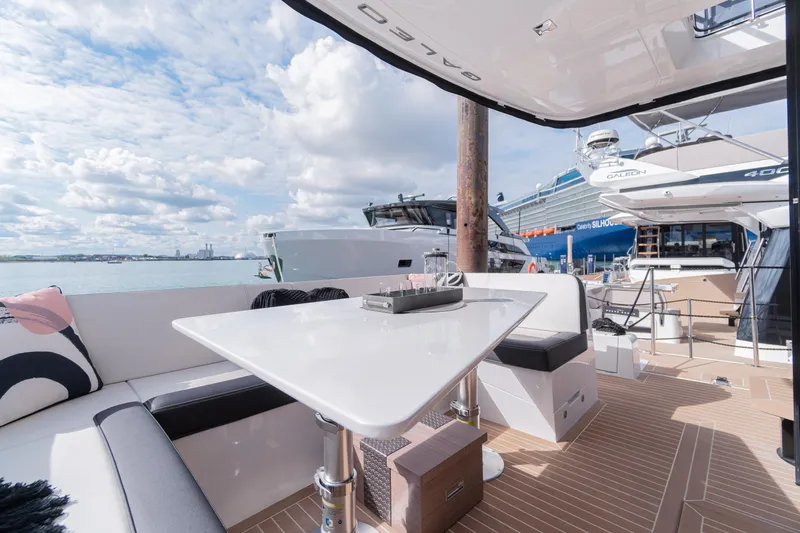 Allouise Yacht Photos Pics Galeon 460 Fly 2022 yacht deck with seating and table, docked at marina.