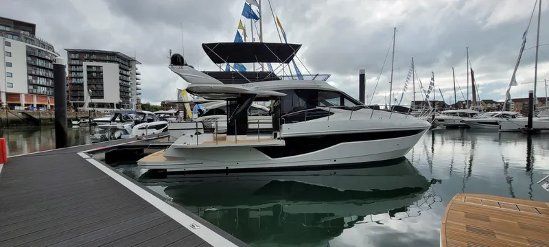 Allouise Yacht Photos Pics 2022 Galeon 460 Fly yacht docked in a marina, surrounded by other boats.