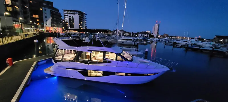 Allouise Yacht Photos Pics 2022 Galeon 460 Fly yacht illuminated at night in a marina setting.