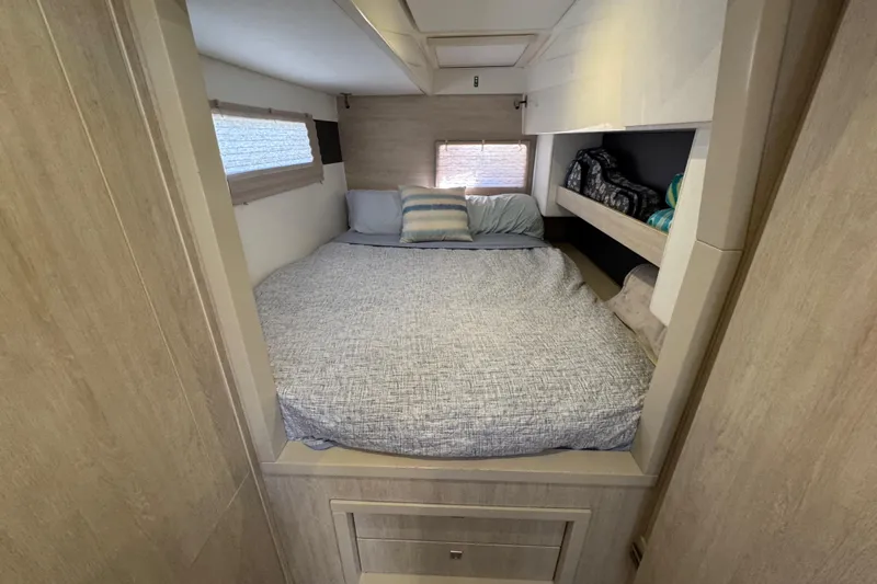Daylight Yacht Photos Pics Cozy bedroom interior of 2018 Leopard 40 catamaran with bed and storage shelves.