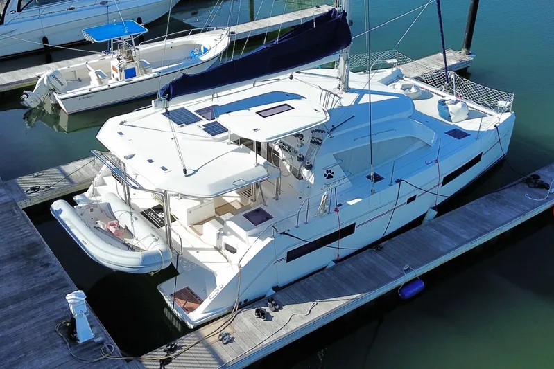 Daylight Yacht Photos Pics 2018 Leopard 40 catamaran docked at marina, featuring solar panels and inflatable dinghy.