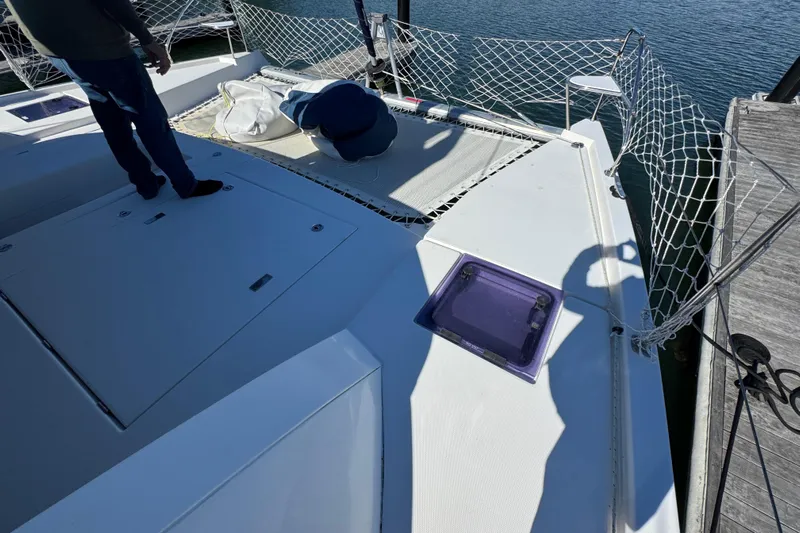 Daylight Yacht Photos Pics 2018 Leopard 40 catamaran deck with netting and hatch, docked by the water.