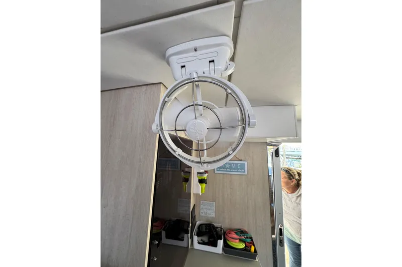 Daylight Yacht Photos Pics Ceiling fan inside 2018 Leopard 40 catamaran cabin with visible storage and person.