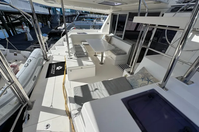 Daylight Yacht Photos Pics Spacious 2018 Leopard 40 catamaran deck with seating and table, docked at marina.