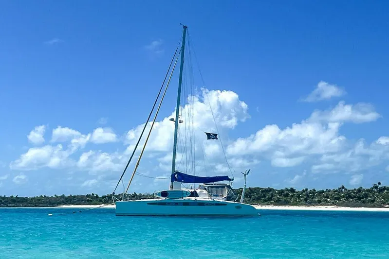Miss Roxy Yacht Photos Pics Sailboat Dolphin 460, 2006 model, anchored in clear turquoise waters under a blue sky.