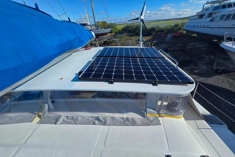 Miss Roxy Yacht Photos Pics Sailboat with solar panels and wind turbine, Dolphin 460 model, 2006, docked under blue sky.