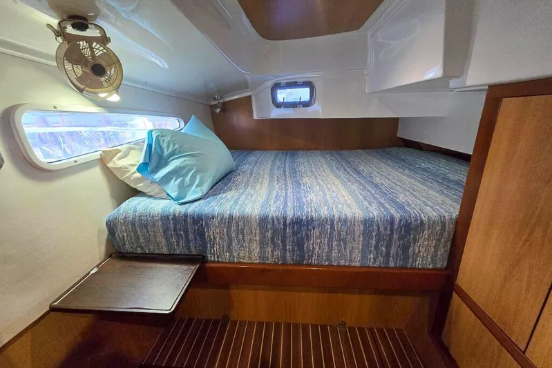 Miss Roxy Yacht Photos Pics Cozy cabin interior of 2006 Dolphin 460 yacht with bed, window, and fan.