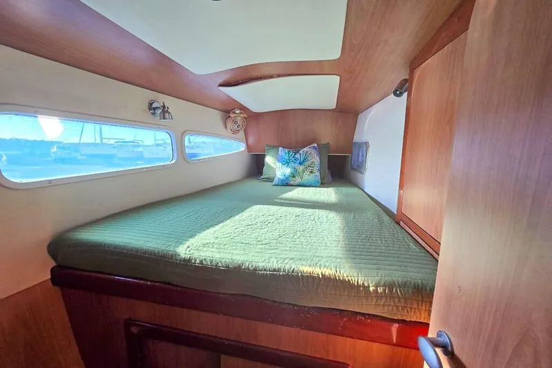 Miss Roxy Yacht Photos Pics Cozy cabin interior of 2006 Dolphin 460 yacht with green bedding and porthole windows.