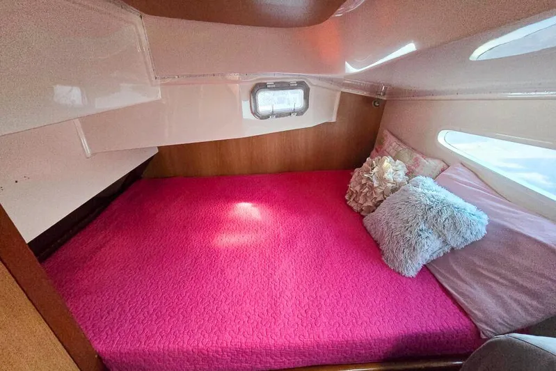 Miss Roxy Yacht Photos Pics Cozy cabin interior of 2006 Dolphin 460 with pink bedding and decorative pillows.