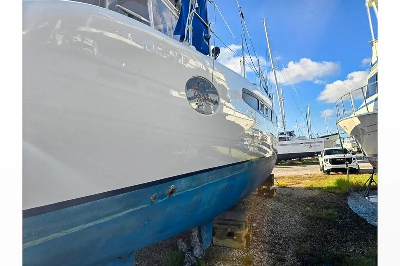 Miss Roxy Yacht Photos Pics 2006 Dolphin 460 sailboat on land, surrounded by other boats under a clear blue sky.