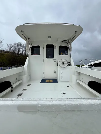  Yacht Photos Pics 2014 Ocean Sport Legacy #4 boat with spacious deck and cabin under cloudy skies.