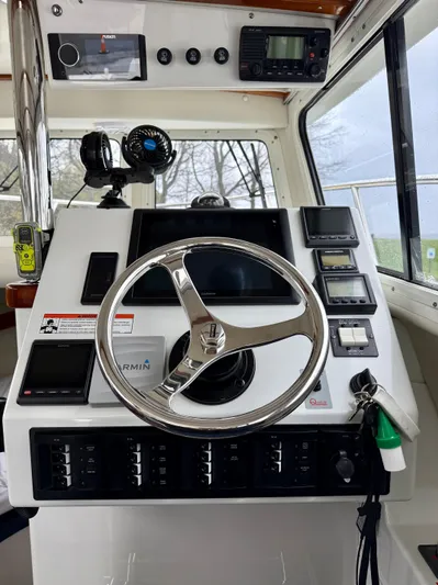  Yacht Photos Pics Control panel of a 2014 Ocean Sport Legacy #4 boat with steering wheel and navigation instruments.