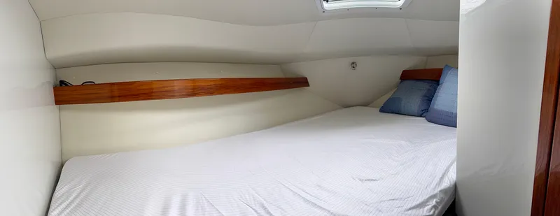  Yacht Photos Pics Cozy cabin interior of 2014 Ocean Sport Legacy #4 with bed and wooden accents.