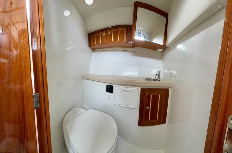  Yacht Photos Pics Compact bathroom in 2014 Ocean Sport Legacy #4 boat with wooden cabinets and modern fixtures.