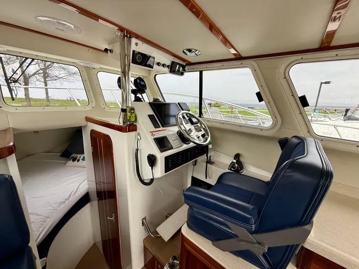  Yacht Photos Pics 2014 Ocean Sport Legacy #4 boat interior with helm, blue seat, and cozy cabin bed.