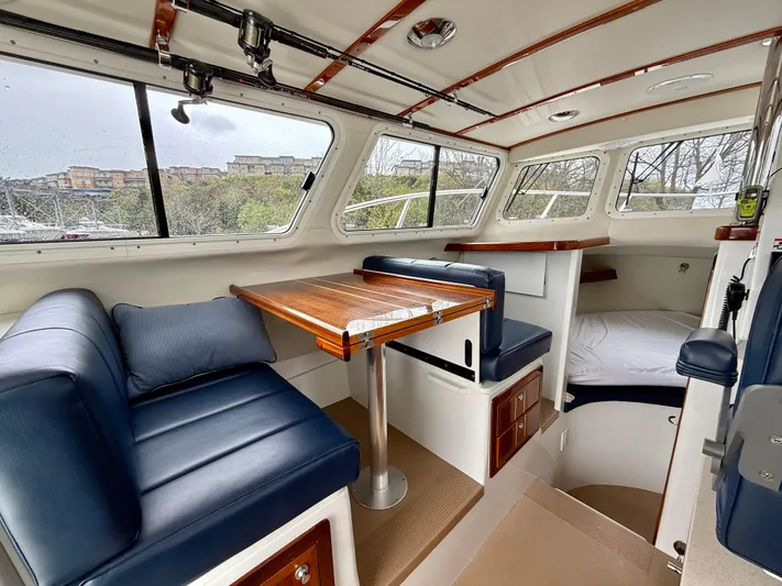  Yacht Photos Pics Interior of 2014 Ocean Sport Legacy #4 boat with blue seating and wooden table.