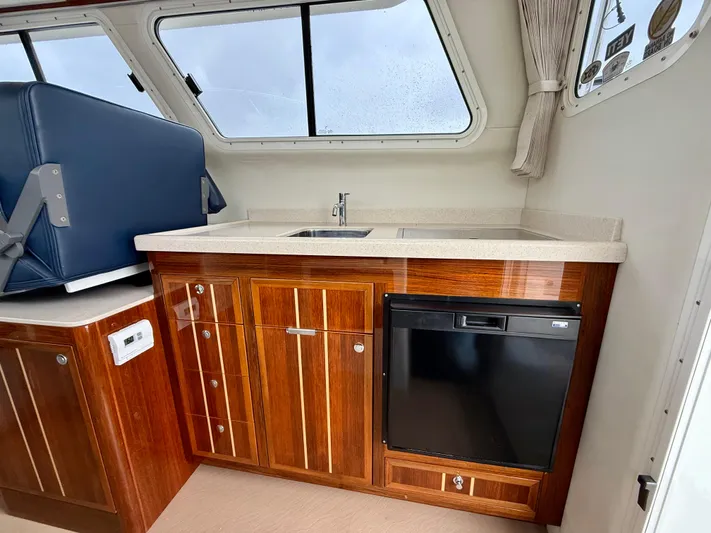  Yacht Photos Pics 2014 Ocean Sport Legacy #4 boat interior with wooden cabinetry and compact kitchenette.
