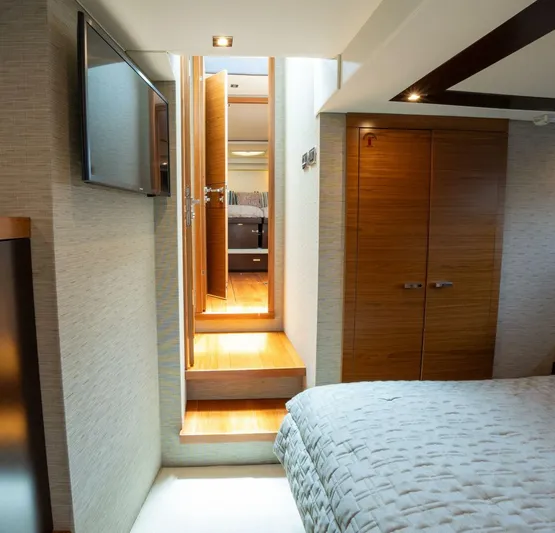 True North Yacht Photos Pics Interior of 2017 Tiara Yachts F53 Flybridge, featuring a cozy bedroom and wooden accents.