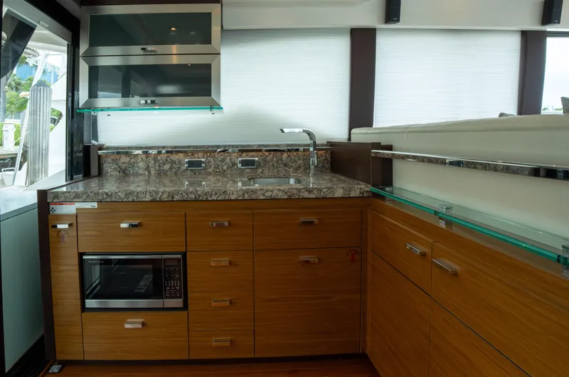 True North Yacht Photos Pics Luxurious kitchen interior of 2017 Tiara Yachts F53 Flybridge with modern appliances and wood cabinetry.