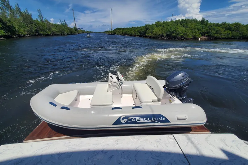 True North Yacht Photos Pics Inflatable boat on water near Tiara Yachts F53 Flybridge, 2017 model, scenic river backdrop.