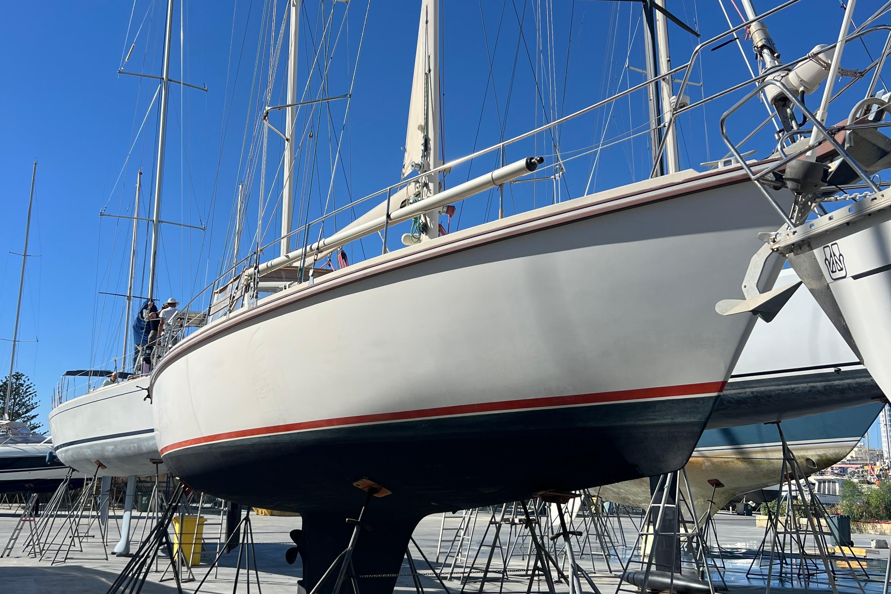 1995 Amel Santorin 46 sailboat on dry dock under clear blue sky.