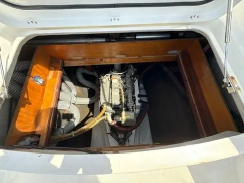 Ivana V Yacht Photos Pics Engine compartment of a 2012 Lagoon 450 catamaran, showcasing mechanical components and wooden paneling.