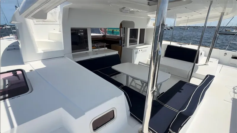 Ivana V Yacht Photos Pics Spacious deck of 2012 Lagoon 450 catamaran with seating and table, docked at marina.