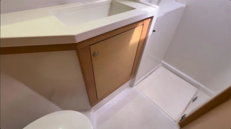 Ivana V Yacht Photos Pics Bathroom interior of 2012 Lagoon 450 yacht, featuring a compact sink and wooden cabinet.
