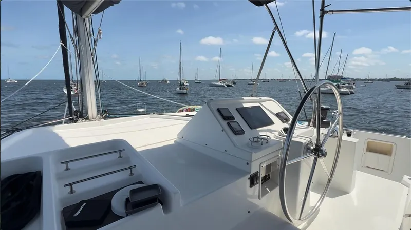 Ivana V Yacht Photos Pics Lagoon 450 catamaran helm with ocean view, 2012 model, featuring navigation equipment and steering wheel.