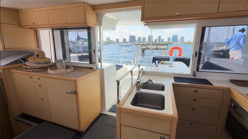 Ivana V Yacht Photos Pics Interior of 2012 Lagoon 450 catamaran with kitchen view and marina backdrop.