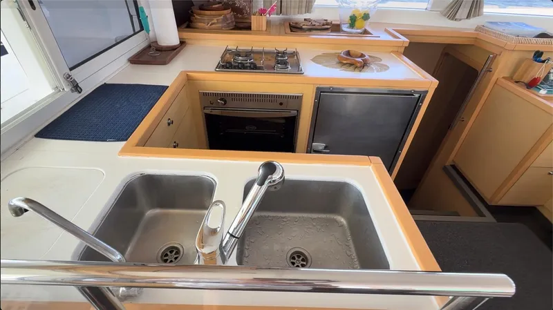 Ivana V Yacht Photos Pics Modern kitchen in a 2012 Lagoon 450 yacht with dual sinks and compact appliances.