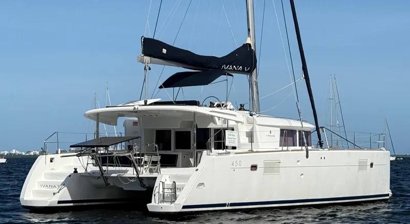 Ivana V Yacht Photos Pics 2012 Lagoon 450 catamaran sailing on calm waters under a clear blue sky.