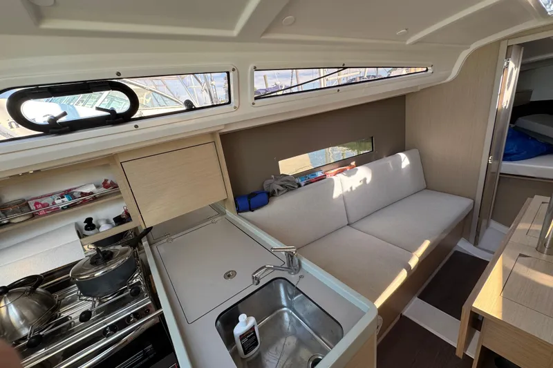 Kaifu Yacht Photos Pics Interior of 2020 Beneteau Oceanis 30.1 yacht, featuring a compact kitchen and cozy seating area.