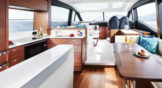  Yacht Photos Pics Luxurious interior of 2025 Princess S62 yacht with modern kitchen and seating area.