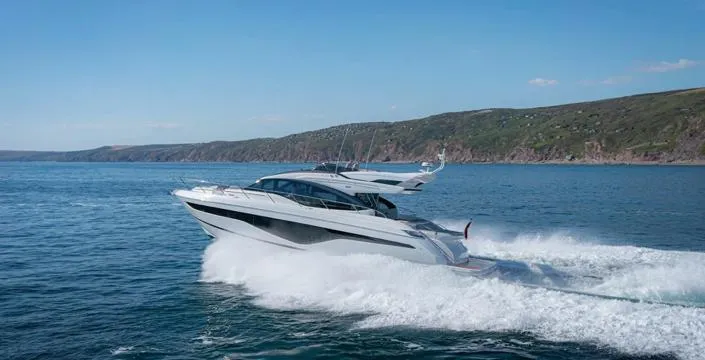  Yacht Photos Pics 2025 Princess S62 yacht cruising on open water near a scenic coastline.