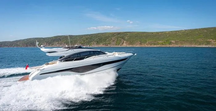  Yacht Photos Pics 2025 Princess S62 yacht cruising on open water with scenic coastline backdrop.