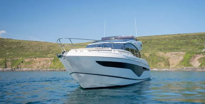  Yacht Photos Pics 2025 Princess S62 yacht on serene water with scenic coastal backdrop.