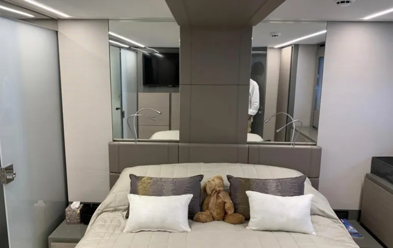 Yacht Photos Pics Luxurious bedroom interior of 2020 Pershing 62 yacht with modern decor and plush bedding.