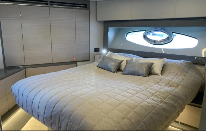 Yacht Photos Pics Luxurious bedroom interior of 2020 Pershing 62 yacht with modern design and cozy bedding.