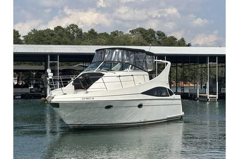  Yacht Photos Pics 2005 Carver 36 Mariner yacht docked on calm water under a cloudy sky.