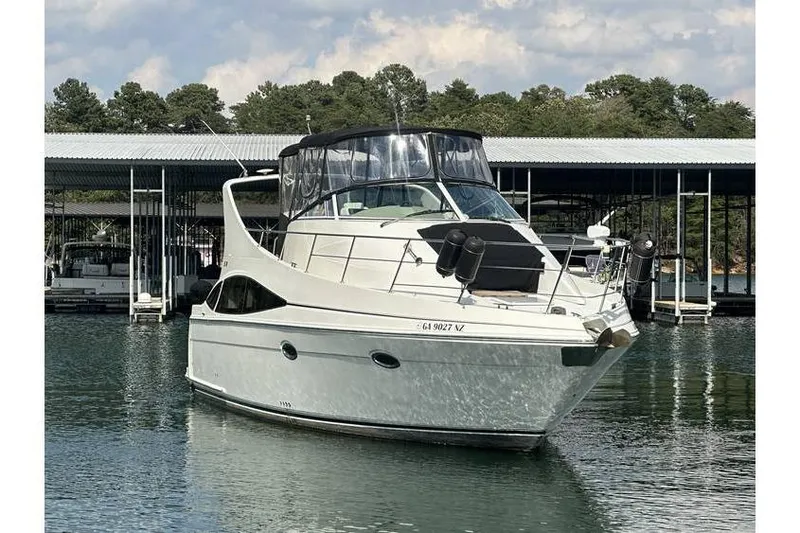  Yacht Photos Pics 2005 Carver 36 Mariner yacht docked on calm water, surrounded by trees and marina.